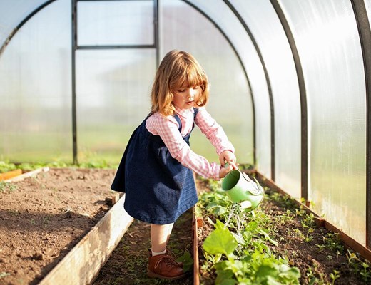 stock-photo-adorable-girl-watering-seedlings-in-the-greenhouse-at-cpring-seasonal-garden-works-little-helper-1087944518